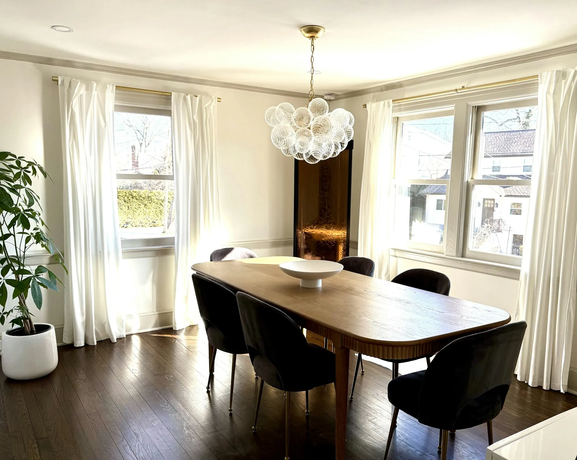 Dining room with an oval table under a globe chandelier